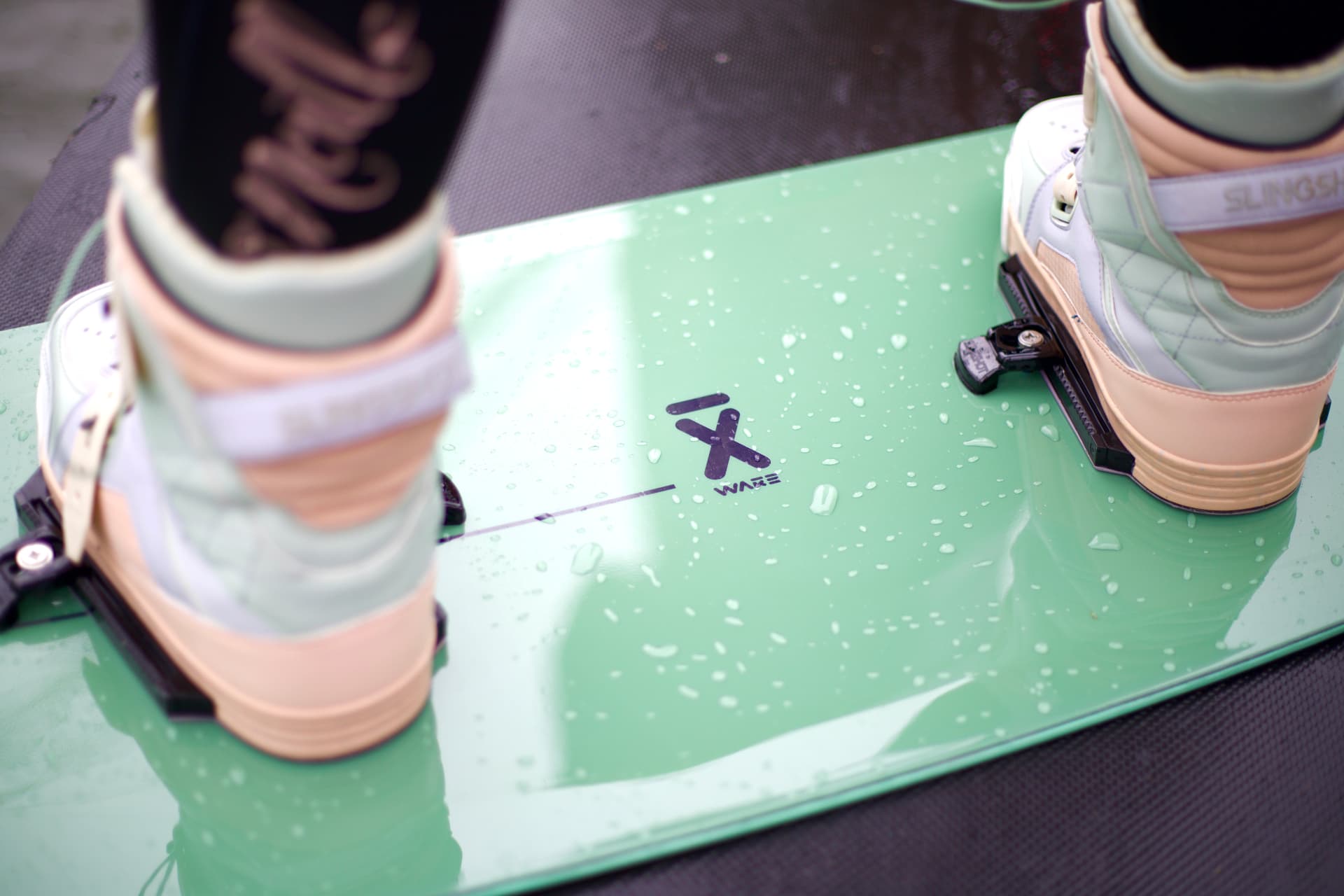 Close-up of wakeboard boots on a green board