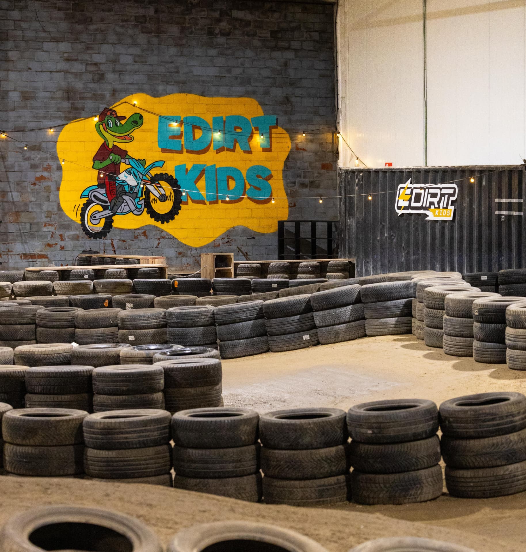 Edirt Kids mural and tire track inside an indoor dirt bike park